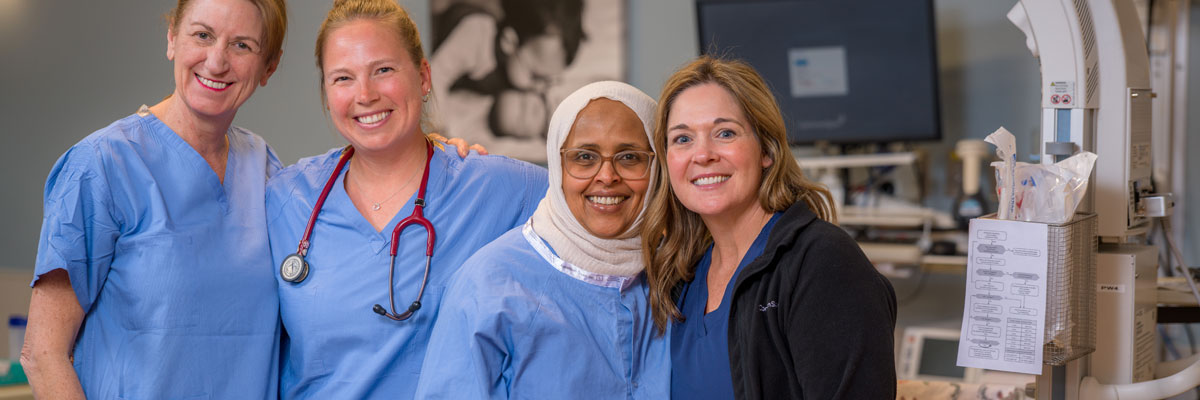A smiling female doctor adminsters care to a young patient